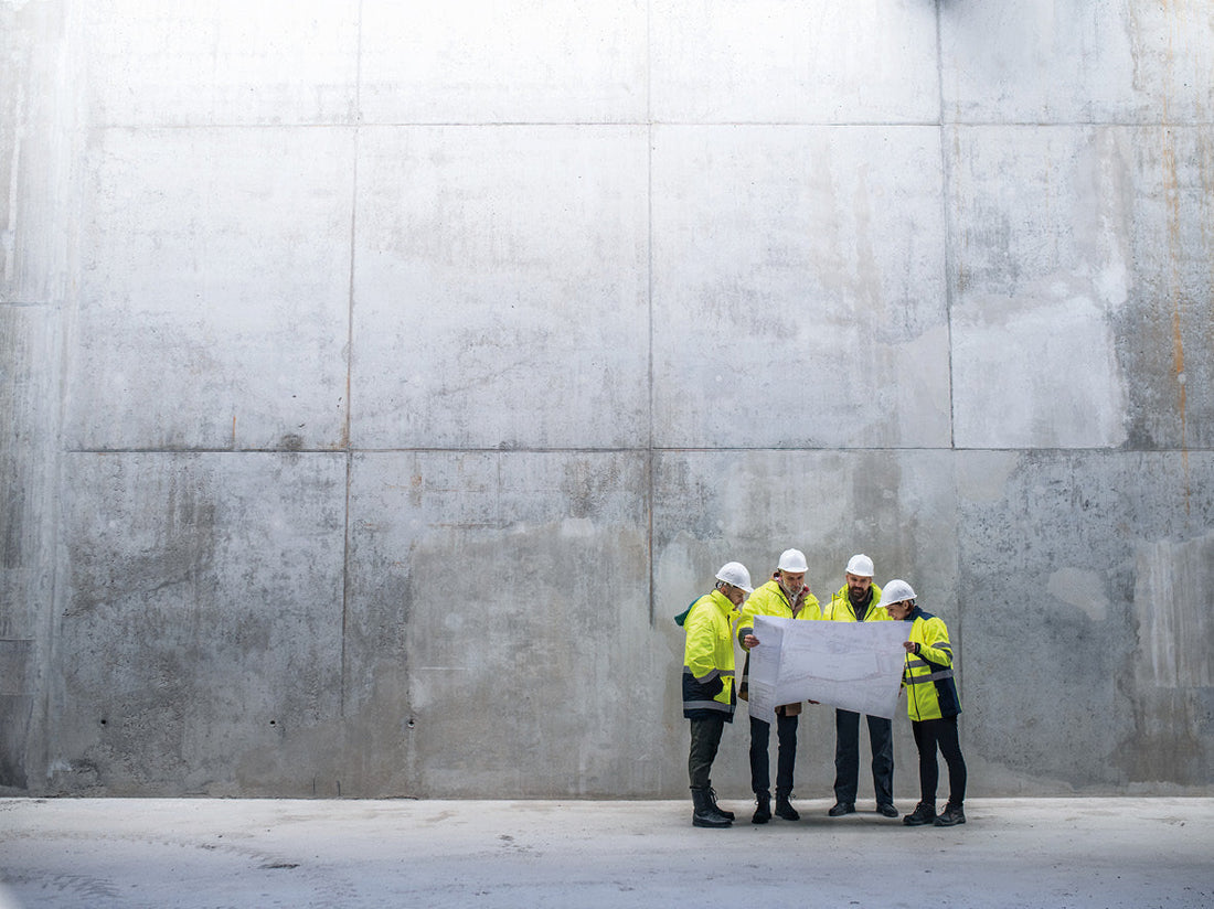 Arbeiter vor einer großen Betonwand