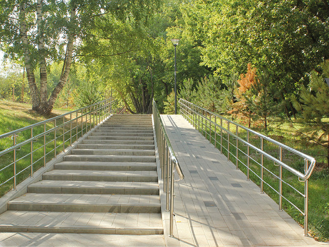 Treppen und Rampe aus Stein mit Handlauf aus Metall in einem sehr schönen Park