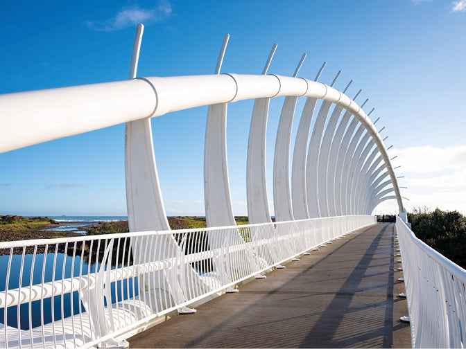 Moderne weiße Brücke über einen Fluss mit nassem Boden