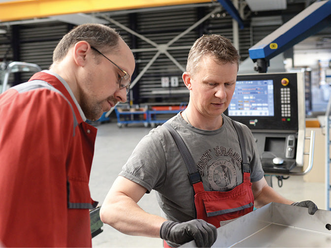 Zwei Männer mit einer Metallwanne